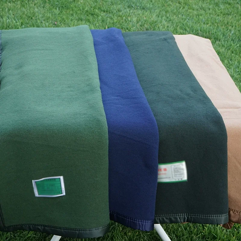 Four textile blankets in different colors on grass