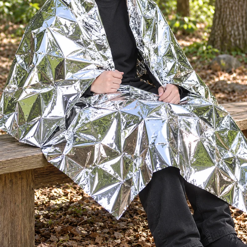 Person draped in a silver emergency blanket
