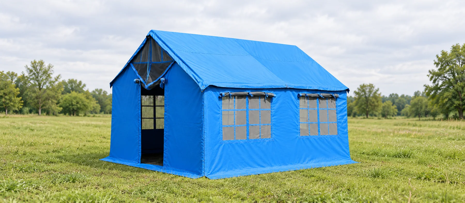 Blue relief tent in a quiet grassy clearing under soft daylight